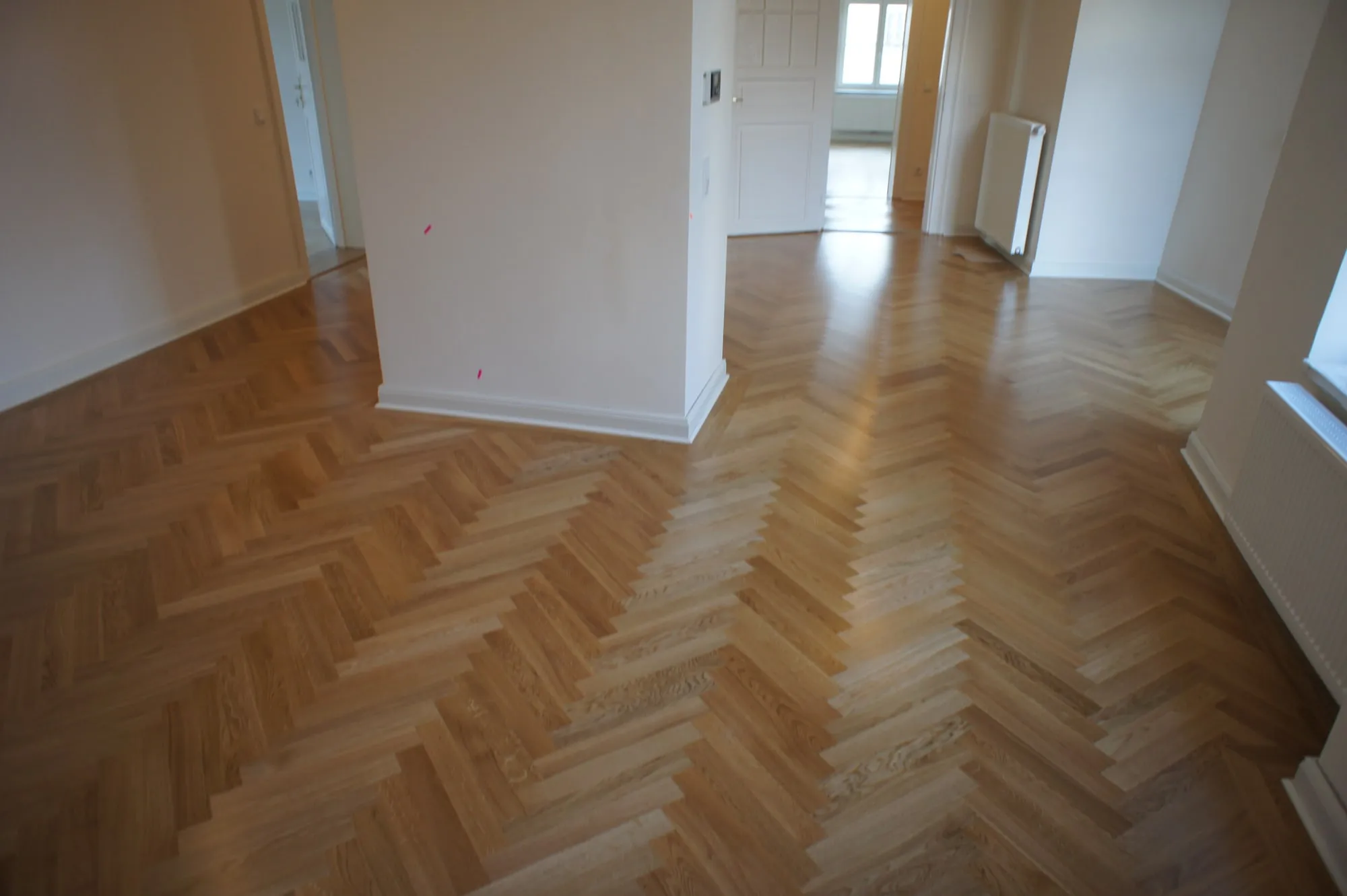 Fischgrätparkett aus Eiche in ineinander übergehenden Räumen einer Altbauwohnung